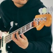 Posido Vega playing the bass guitar with close up of fretboard