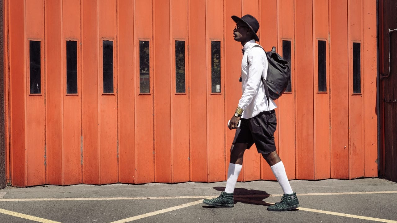 Man walking past a firestation by Clem Onojeghuo
