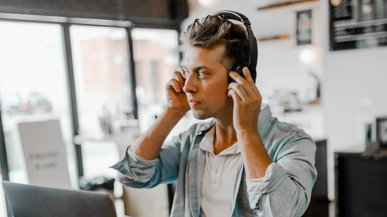 Best Ear Training Apps - Man listending with headphones by Austin Distel