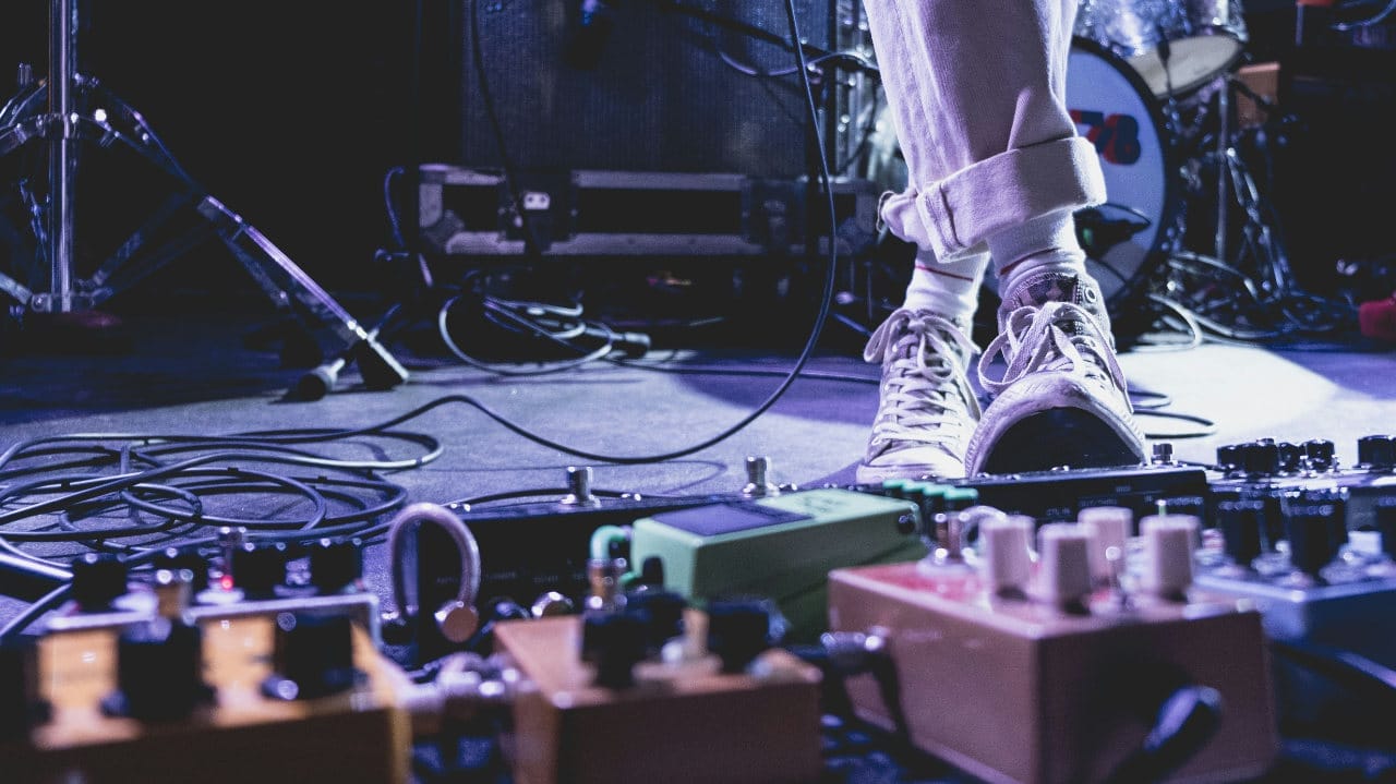 Effects pedals for bass - Image of a pedal board on stage by Dan Burton