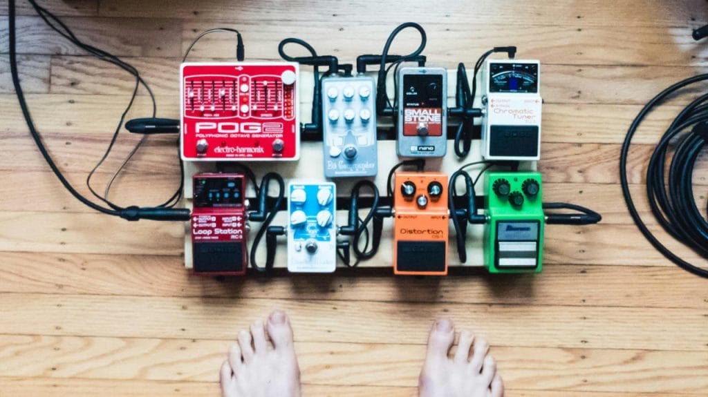 POV of a guitar pedalboard and bare feet by Michael Henry