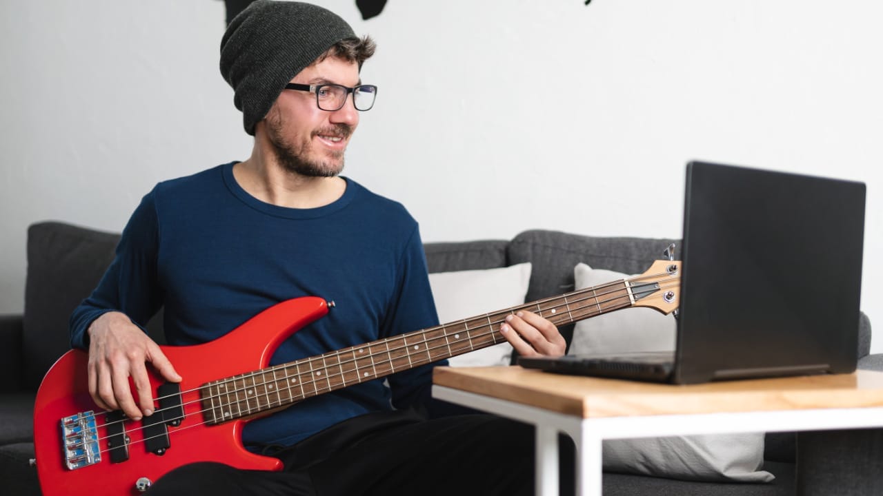 Best Apps For Practicing Jazz Improvisation - Man enjoying learning how to play the bass guitar