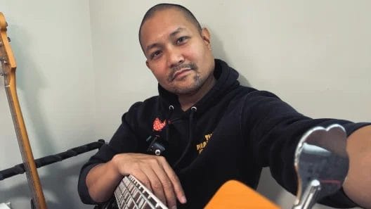 Posido Vega resting with bass guitar